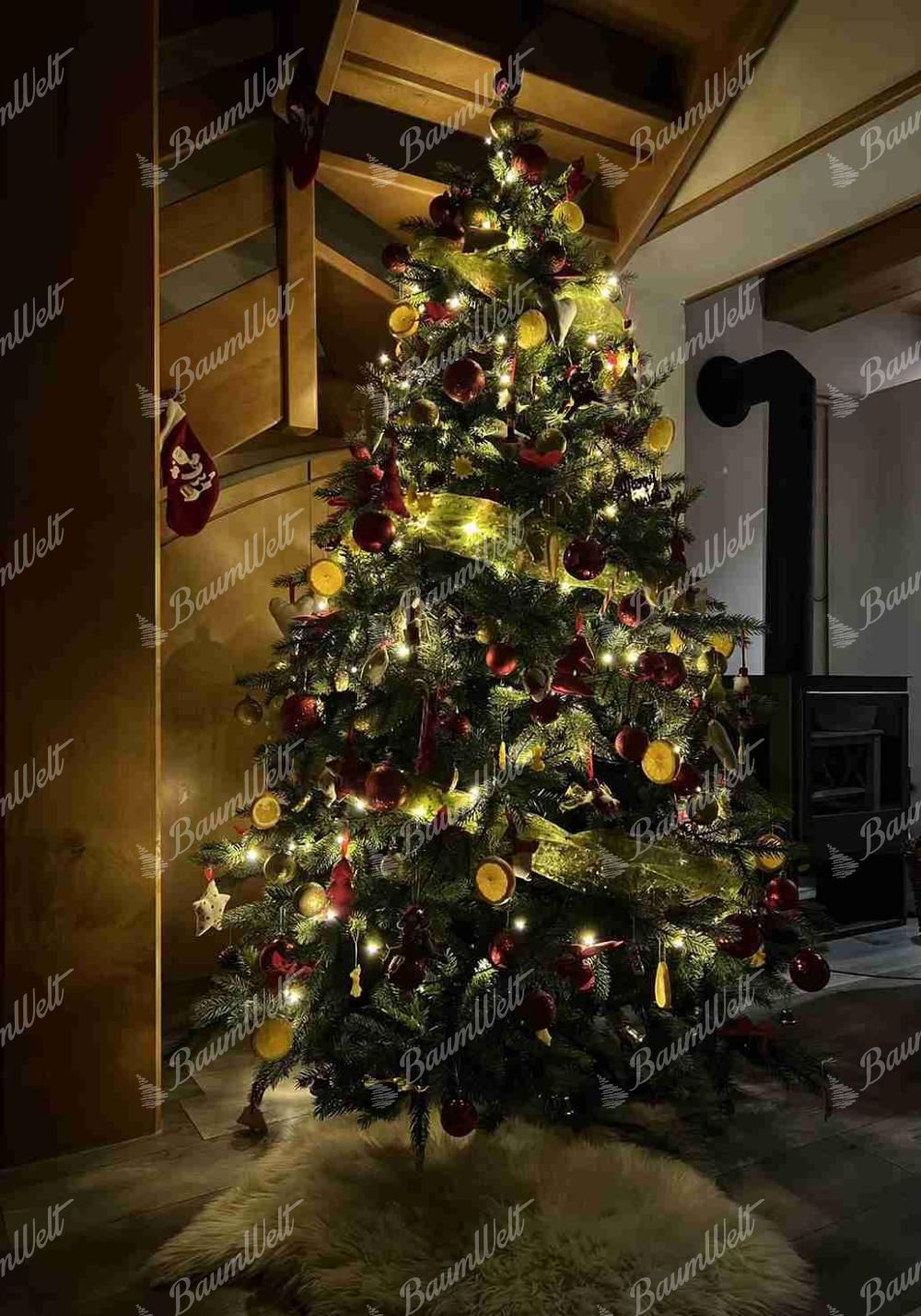 Künstlicher Weihnachtsbaum 3D Skandinavische Fichte 240cm ist mit roten und goldenen Verzierungen und getrockneten Früchten geschmückt