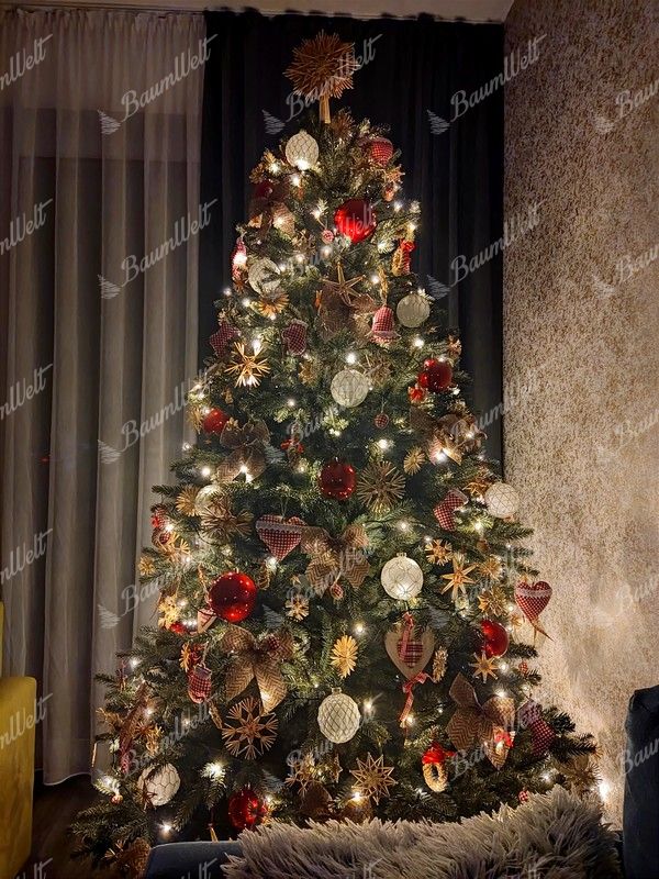 ünstlicher Weihnachtsbaum, grün, dekoriert mit roten und natürlichen Dekorationen, im Wohnzimmer