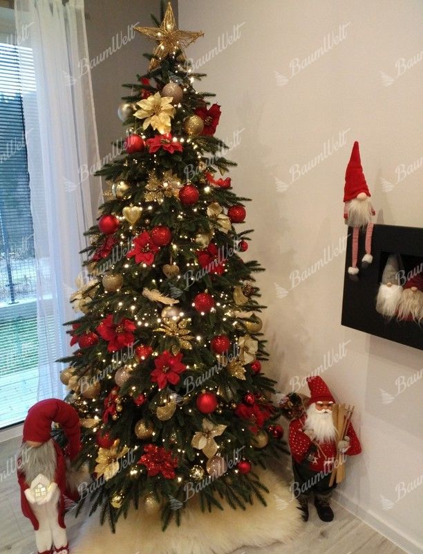 Künstlicher grüner Weihnachtsbaum mit goldenen und roten Ornamenten im Wohnzimmer