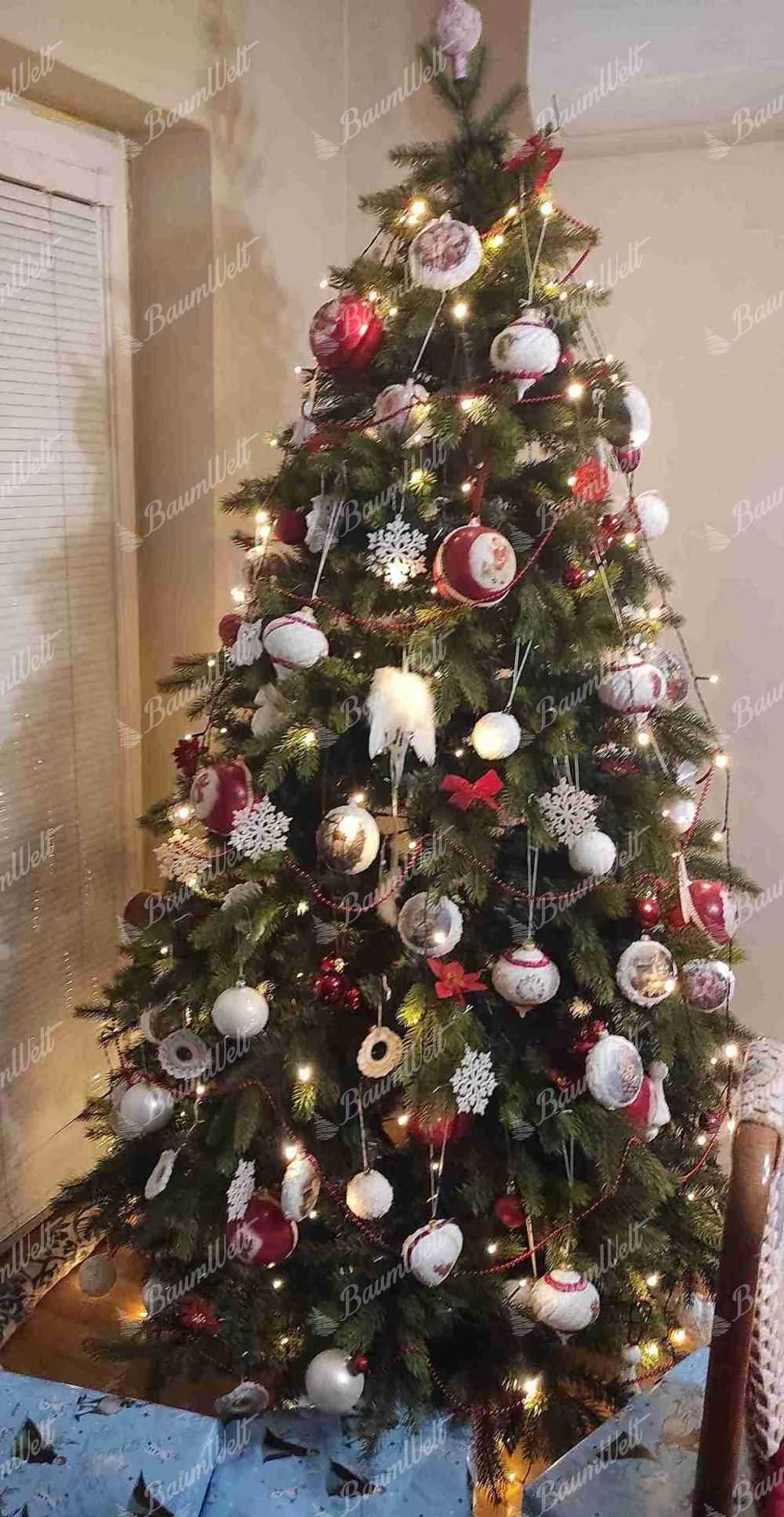 Künstlicher Weihnachtsbaum 3D Skandinavische Fichte 210cm, ist mit weißen und roten Dekorationen verziert