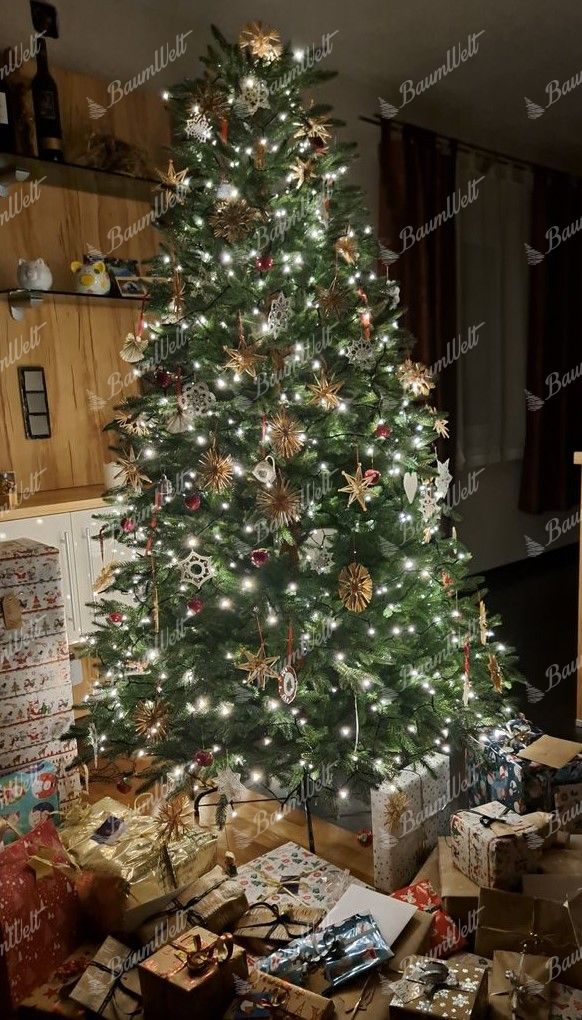 Künstlicher Weihnachtsbaum FULL 3D Alpenfichte 210cm, ist mit goldenen und weißen Dekorationen verziert